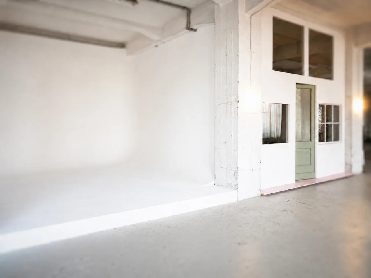 Helles Fotostudio mit großen Sprossenfenstern, Topflanze, LED-Lichttechnik, Stativ und Sitzmöbel